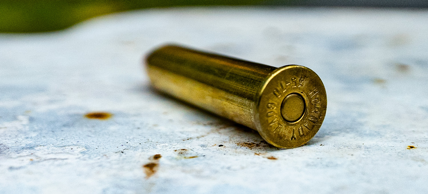 A Hornady 45-70 straight wall cartridge on a target at a shooting range.