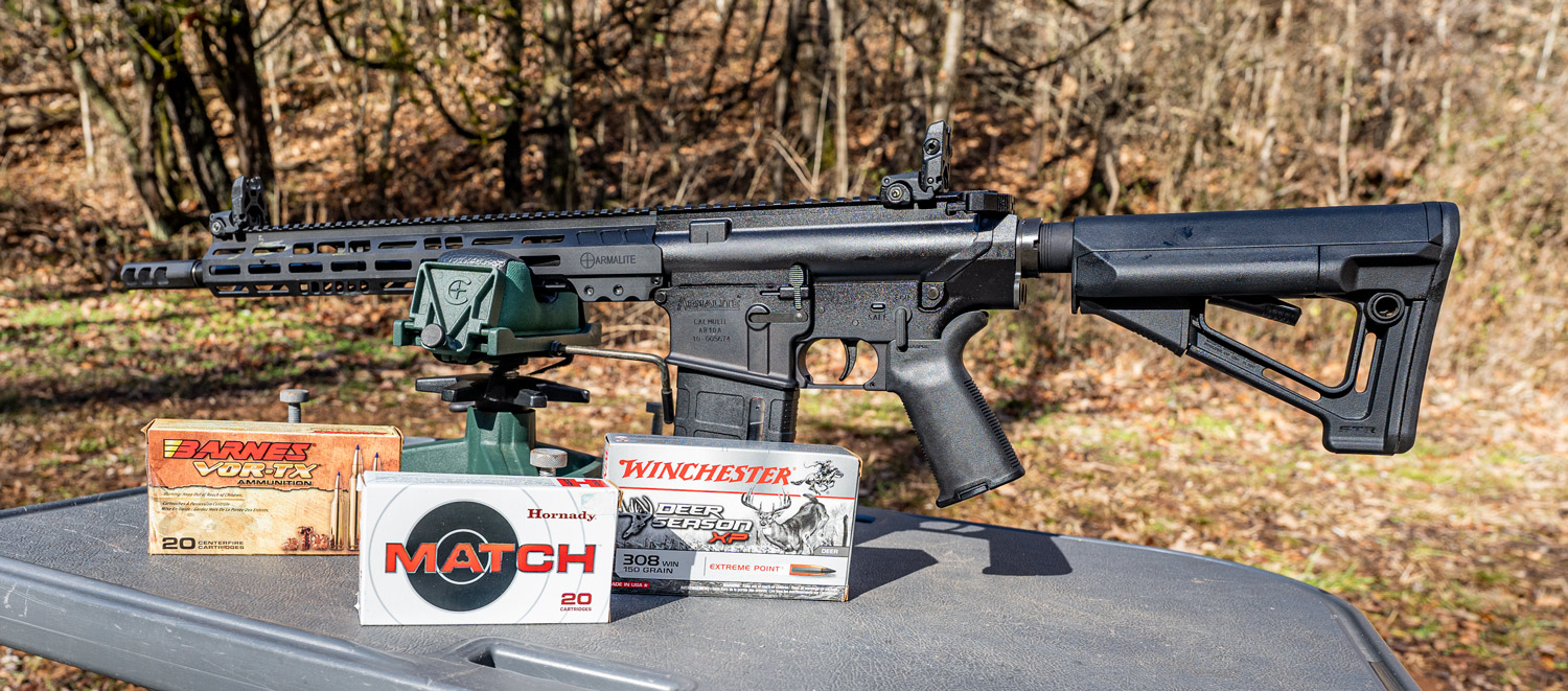 An Armalite AR-10 rifle with ammo on a shooting bench