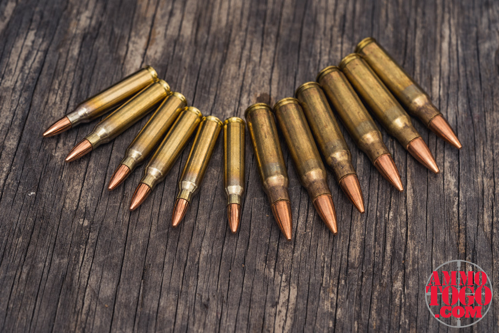 photo of 223 ammo next to 308 ammo on a sheet of plywood