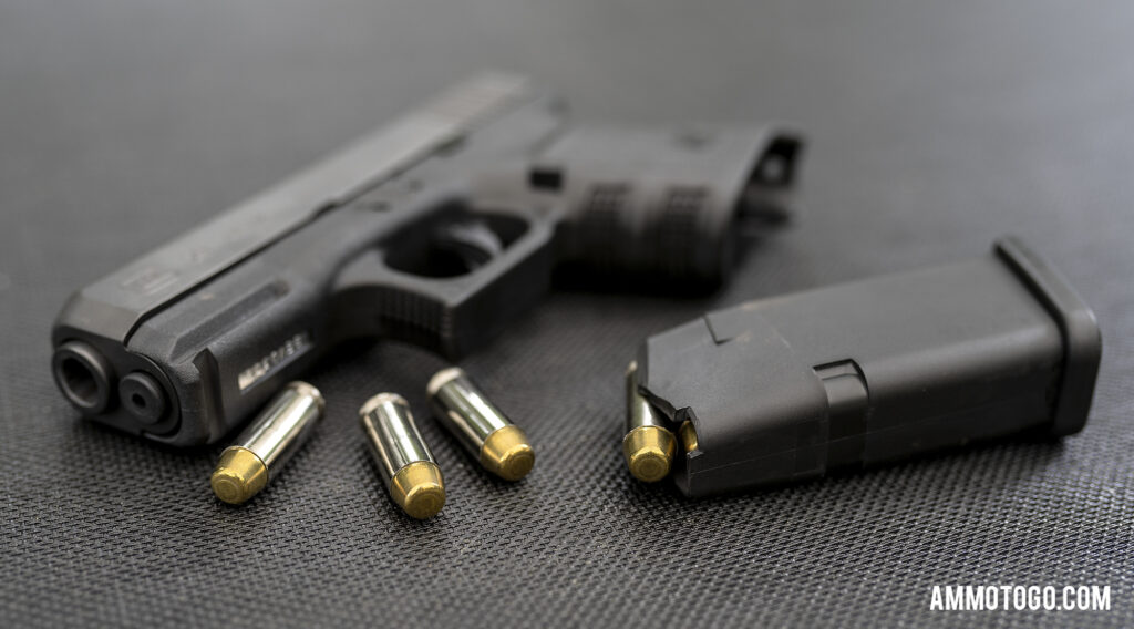 Glock 29 sitting on a table with 10mm ammunition and magazine unloaded