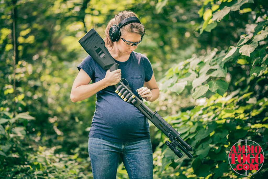 a pregnant woman reloading a 12 gauge shotgun outdoors