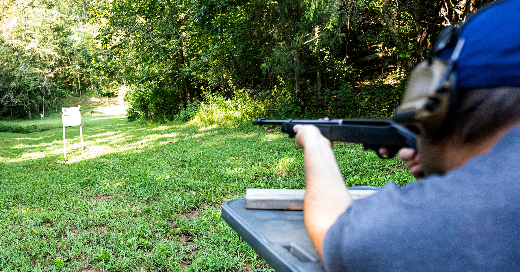 The author firing a rifle at a shooting range