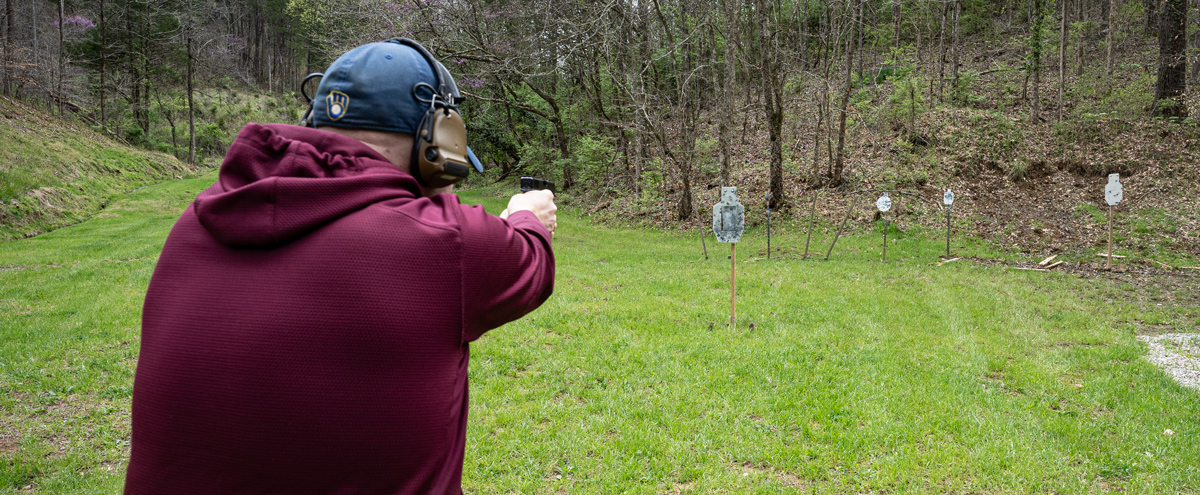 The author firing 9mm ammo at a shooting range during a training session.