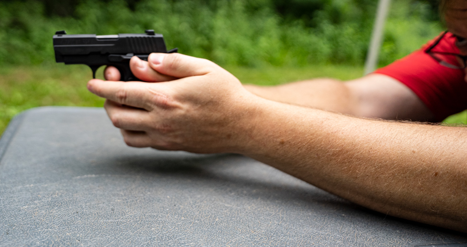 Shooting a pocket pistol at the range from a shooting bench