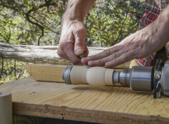 Using a chisel to carve out designs on the barrel of the duck call