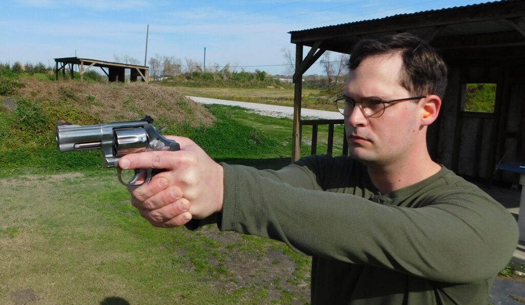 The author firing the Colt Viper revolver at an outdoor shooting range as part of his work in writing this review.