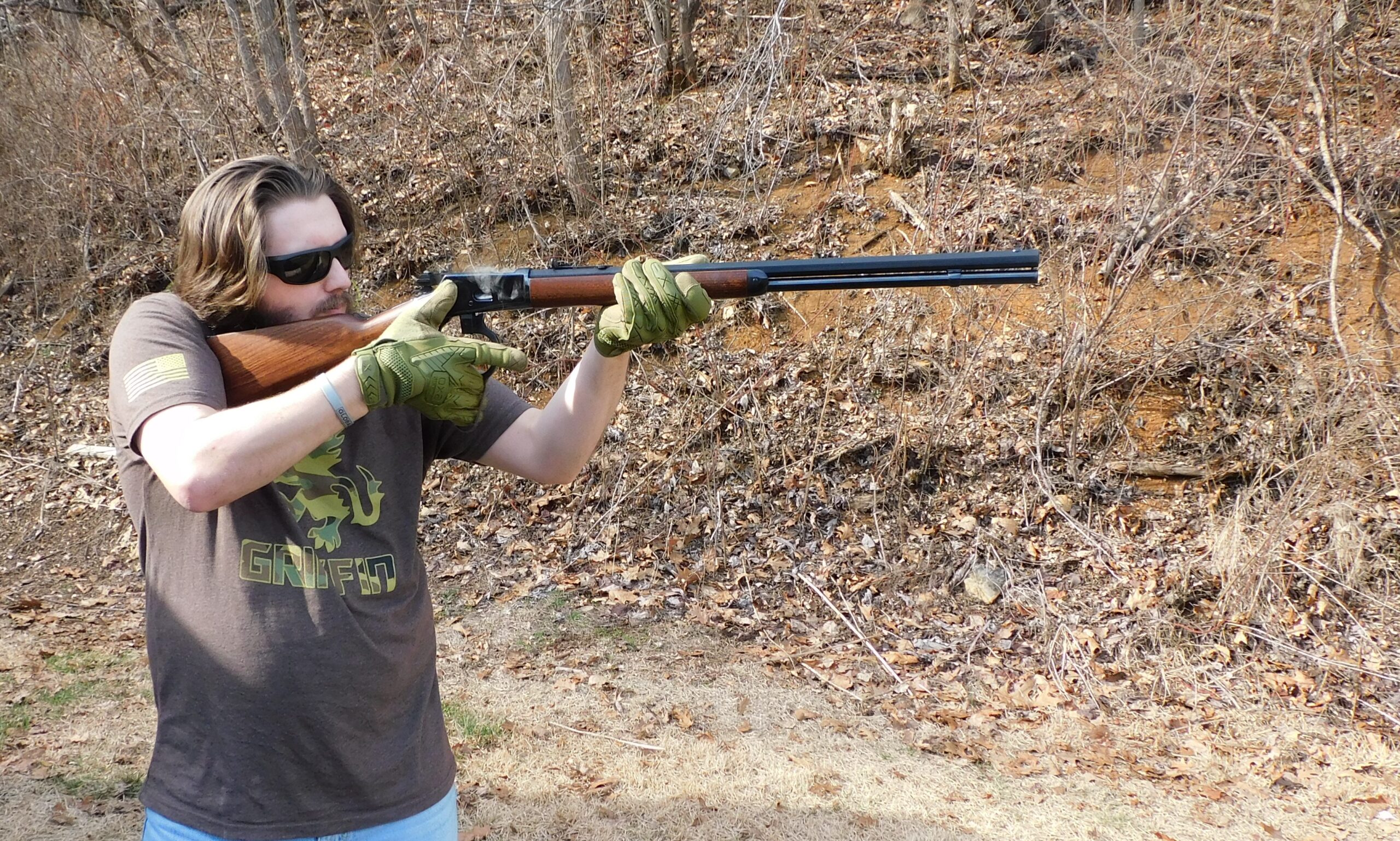 Shouldering the Heritage 92 rifle Man in Griffin t-shirt aiming Heritage 92 lever-action rifle outdoors in winter