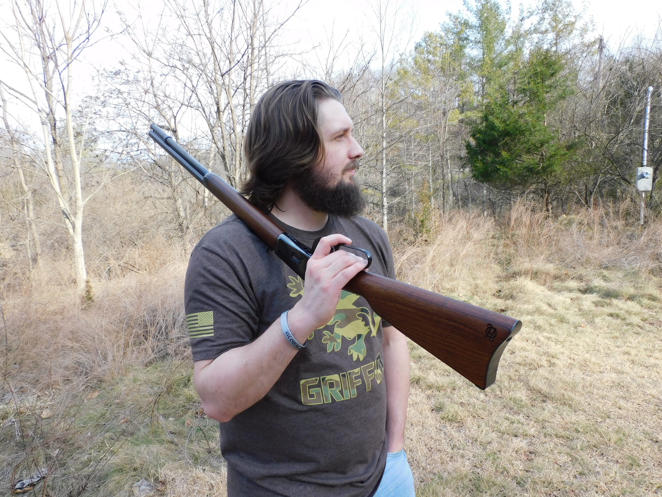 The author with the rifle on his shoulder Man carrying Heritage 92 lever-action rifle over shoulder at outdoor range in winter
