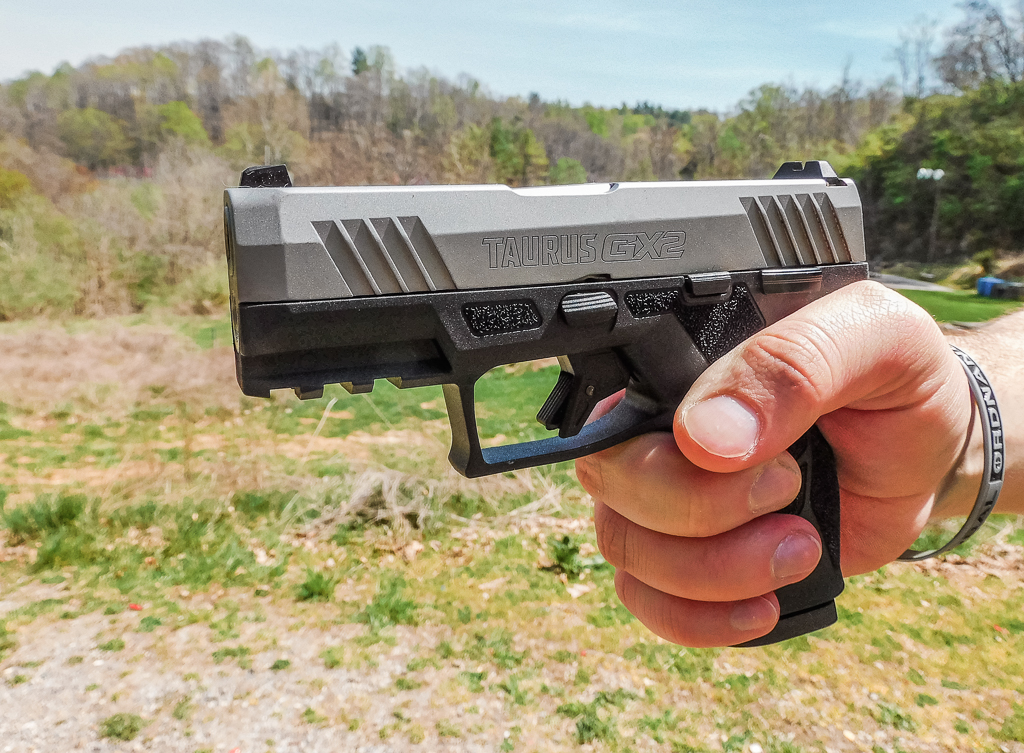 Shooter holding a Taurus GX2 with visible branding on the left hand side
