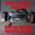 snub nose revolvers and ammo on a shooting bench
